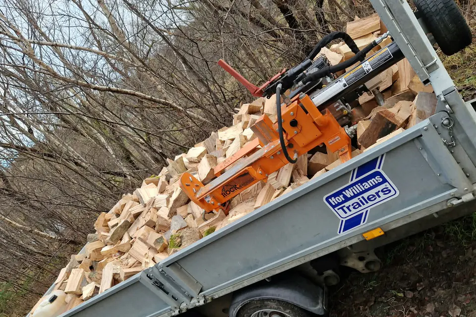 Trailer carrying timber and professional equipment